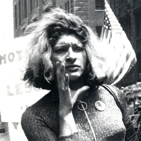 A woman holds her hand to her mouth at a protest.